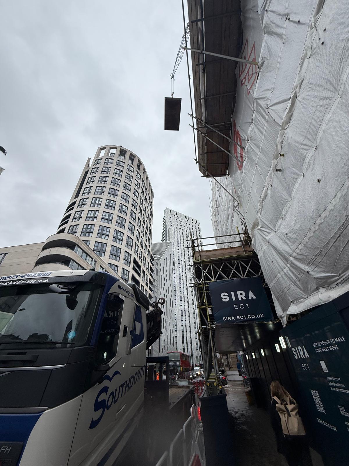 The Southdown team lift a road plate higher above a busy London street